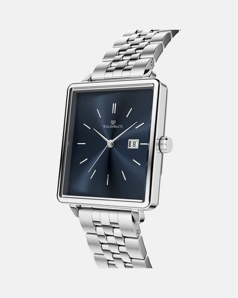 A square womens watch in silver from WALDOR & CO. with blue sunray dial and a second hand. The model is Delight 32 Chelsea 28x32mm. 