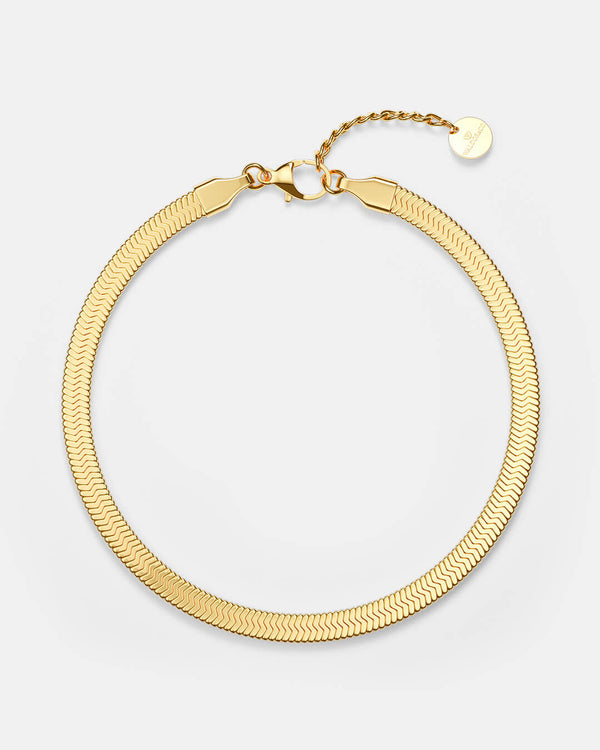 A polished stainless steel chain in 14k gold from Waldor & Co. One size. The model is Eze Chain Polished
