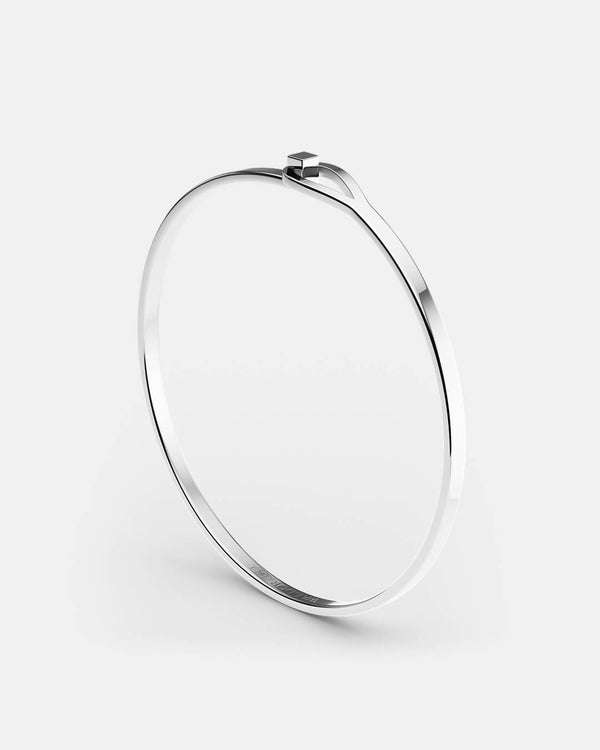 A polished stainless steel bangle in silver from Waldor & Co. The model is Signature Bangle Polished 