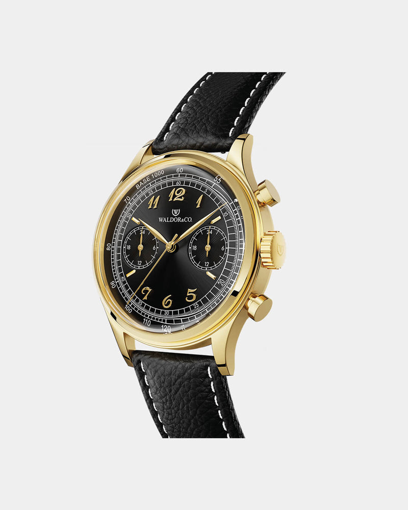A round mens watch in 14K gold-plated 316L stainless steel from Waldor & Co. with black sunray dial. Curved mineral glass with 5 layers anti-reflective coating. Seiko VD32 movement. Genuine leather strap. The model is Avant 39 Eze.