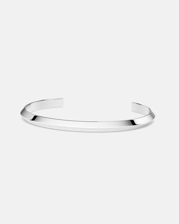 A polished stainless steel bangle in silver from Waldor & Co. One size. The model is Triangle Bangle Polished